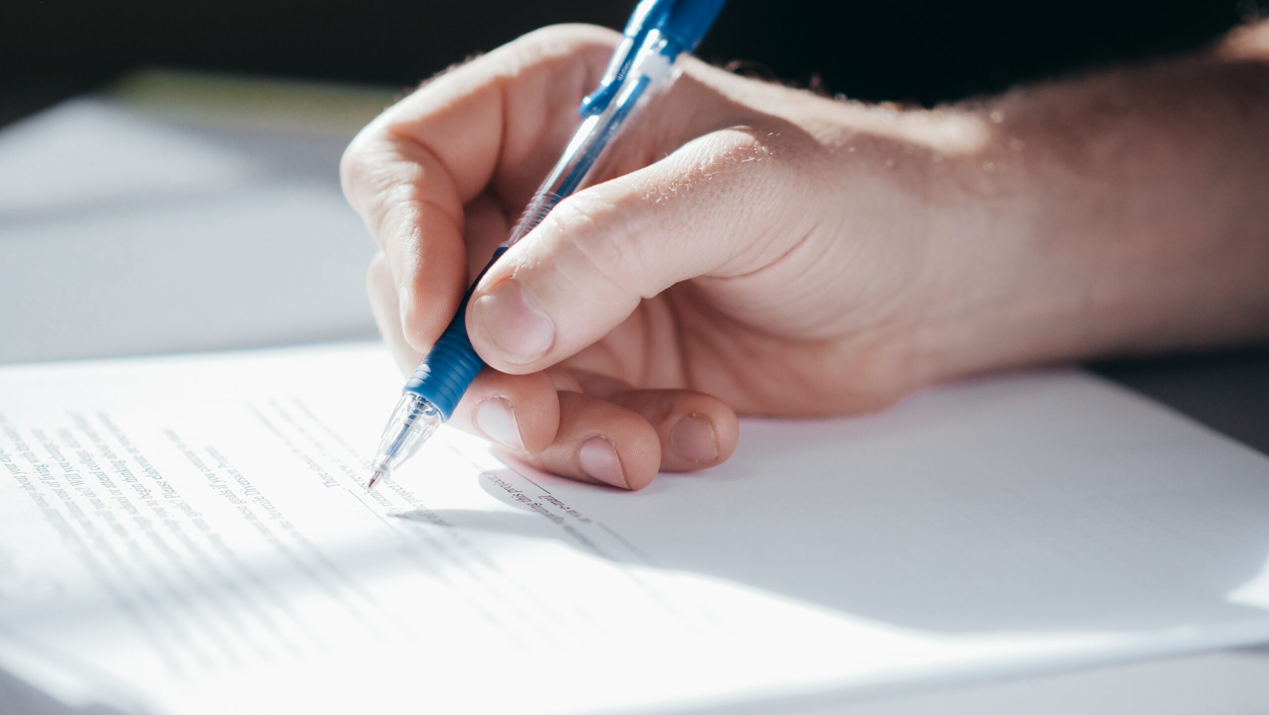 hand holding blue pen